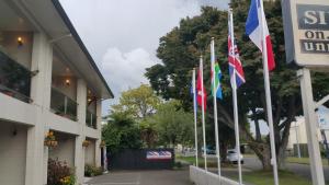 a row of flags in front of a building at Six On Union Motel in Rotorua