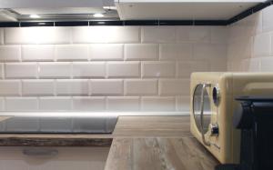 a kitchen with white subway tiles on the wall at Bonito Loft en L'Ampolla in L'Ampolla