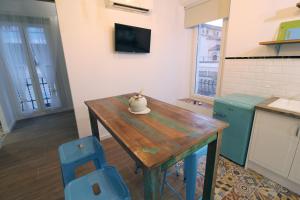 a kitchen with a wooden table and blue chairs at Bonito Loft en L'Ampolla in L'Ampolla