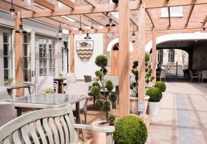 a patio with tables and chairs and a wooden pergola at The Beverley Arms Hotel in Beverley