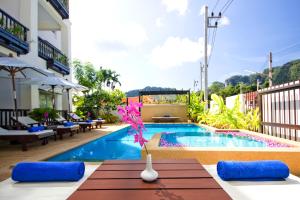 a swimming pool with a table and chairs and a pool at Krabi Apartment-SHA Extra Plus in Ao Nang Beach