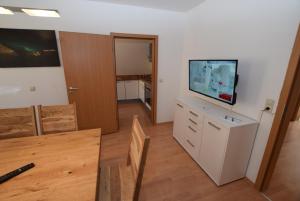- un salon avec une commode et une télévision à écran plat dans l'établissement Apartment Stuttgart Südheim, à Stuttgart