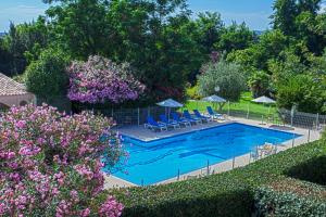 a pool with chairs and umbrellas in a yard at Chez Walter in Lucciana