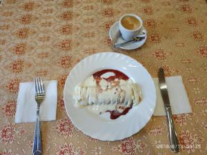 a piece of cake on a plate with a cup of coffee at Ceasar in Mykolaiv