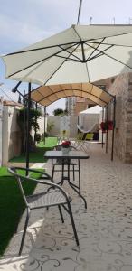 a table and chairs under an umbrella on a patio at Shahal Apartments in Beer Sheva