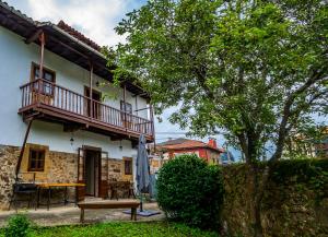 San Martín de Luiña的住宿－Casa Justa，带阳台和木桌的度假屋