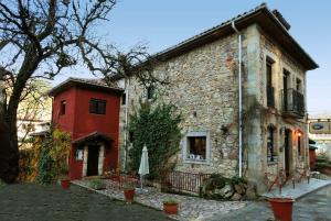 an old stone building with a table and an umbrella at Pensión Susierra in Cardes