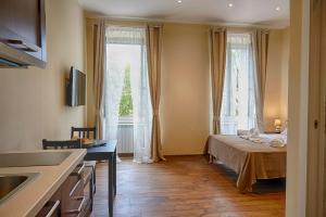 Kleines Zimmer mit einem Bett und einem Fenster in der Unterkunft Miramare Luxury Suites in Triest
