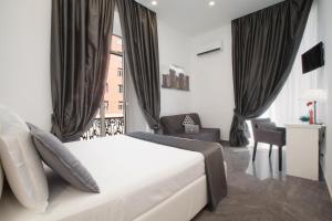 een slaapkamer met een groot wit bed en een raam bij Suite dei Catalani in Napels