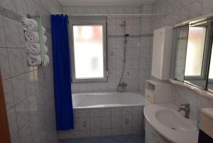 ein Badezimmer mit einer Badewanne und einem Waschbecken in der Unterkunft Apartment Stuttgart Südheim in Stuttgart