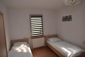 2 Betten in einem Zimmer mit Fenster in der Unterkunft Apartment Stuttgart Südheim in Stuttgart