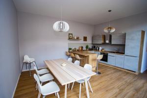 cocina y comedor con mesa de madera y sillas en Eckhof Domizil en Gotha