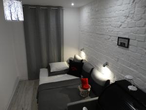 ein Wohnzimmer mit einem Sofa und einer weißen Ziegelwand in der Unterkunft APARTAMENT "Eli" in Toruń