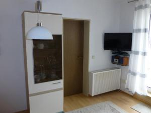 ein Wohnzimmer mit einem TV und eine Tür mit einem Fenster in der Unterkunft Villa Marina Wangerooge in Wangerooge