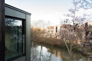 a window view of a river from a house at The Cliffside Chalet - Modern 3BDR Riverside Home in Bath