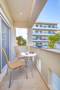 uma varanda com uma mesa e cadeiras e um edifício em Central Luxurious Apartments Close to the Sea em Rodes
