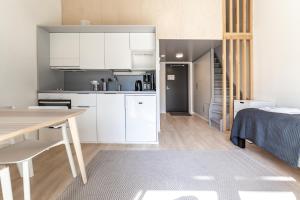 cocina con armarios blancos, mesa y cama en Spot Apartments Martinlaakso, en Vantaa 13 fotos más