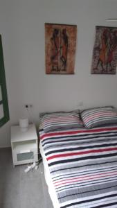 a bed in a bedroom with two pictures on the wall at Puerta del Sol in Caleta De Fuste +16 photos