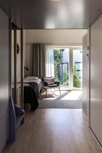 Un dormitorio con una cama y una silla y una ventana. en Spot Apartments Martinlaakso, en Vantaa