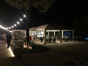 a group of people sitting in a tent at night at Hotel Garden Salento in Torre Vado +57 photos