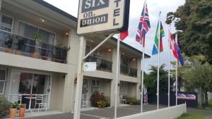 um sinal em frente a um hotel com bandeiras em Six On Union Motel em Rotorua