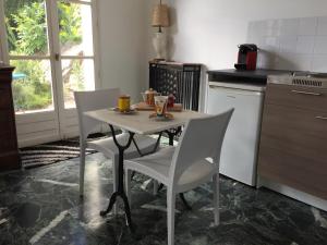 a kitchen with a table and two chairs and a table and a table at La maison du lac in Auvers-sur-Oise