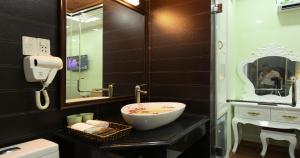 a bathroom with a bowl sink and a mirror at Kawasaki Noi Bai Hotel in Noi Bai