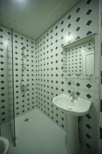 a white bathroom with a sink and a shower at Hotel Comfort in Kutaisi