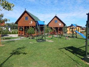 a playground with two houses and a slide at Stumilowy Las Mielenko in Mielenko