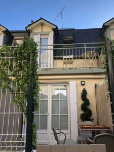 a house with a balcony and a table and chairs at L'IDEAL 9 (hypercentre avec terrasse) in Deauville