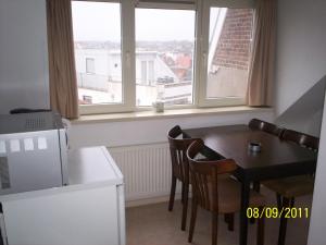 une cuisine avec une table et des chaises ainsi qu'une fenêtre dans l'établissement Hotel Noordzee, à Zandvoort