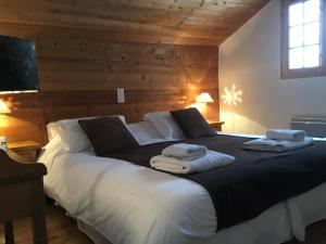 a bedroom with a large bed with towels on it at Chalet Odette in Morzine