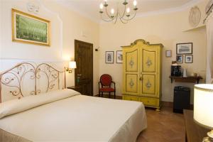 a bedroom with a white bed and a yellow cabinet at Mondo Antico B&B in Cesena