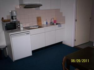 a small kitchen with a sink and a microwave at Hotel Noordzee in Zandvoort
