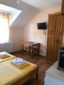 a bedroom with a bed and a table with a tv at Vila de lux in Bela Crkva