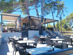 a restaurant with tables and chairs and a staircase at Apartments Mare & Mons Deluxe in Malinska