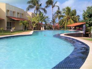 a large swimming pool with blue water at Casa na Rua Principal - Pipa Atlântico in Pipa