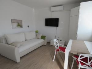 - un salon avec un canapé blanc et une table dans l'établissement Apartments Villa Urbajs, à Vrsar