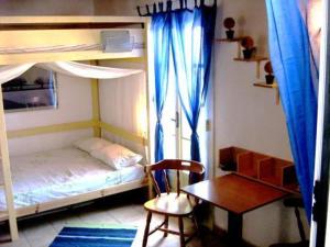 a bedroom with a bunk bed and a desk and a chair at Adonis Guesthouse in Batsi