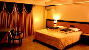 a hotel room with a bed and a table at Praia Sol Hotel in Santa Terezinha de Itaipu