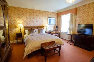 a bedroom with a large bed and a television at The Gretna Chase Hotel in Gretna