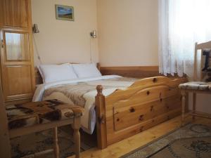 a bedroom with a wooden bed and a window at Орбелус in Govedartsi