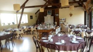 a dining room with tables and chairs with purple table cloth at Hotel du Golf de Clécy in Clécy