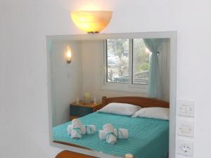 a bedroom with a bed with towels and a window at Paschalitsa Rooms in Prinos