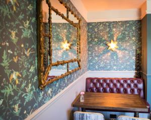 un banco de cuero en una habitación con espejo en The Dundas Arms, en Kintbury