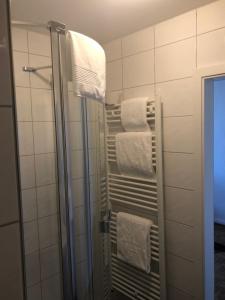 a bathroom with a shower with white towels at Hotel SchlossStuben in Nordkirchen