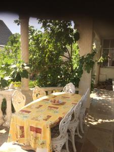 a table with white chairs and a yellow table cloth at Villa in Walsrode in Walsrode