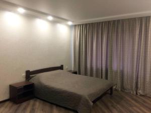 a bedroom with a bed and a window with curtains at Затишна квартира в центрі in Vinnytsya