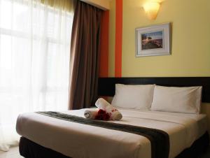 una camera da letto con un letto con un orsacchiotto sopra di Sun Inns Hotel Pasir Penambang (KS Botanic) a Kuala Selangor