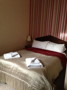1 dormitorio con 1 cama con toallas en Ambrose Hotel, en Barrow-in-Furness